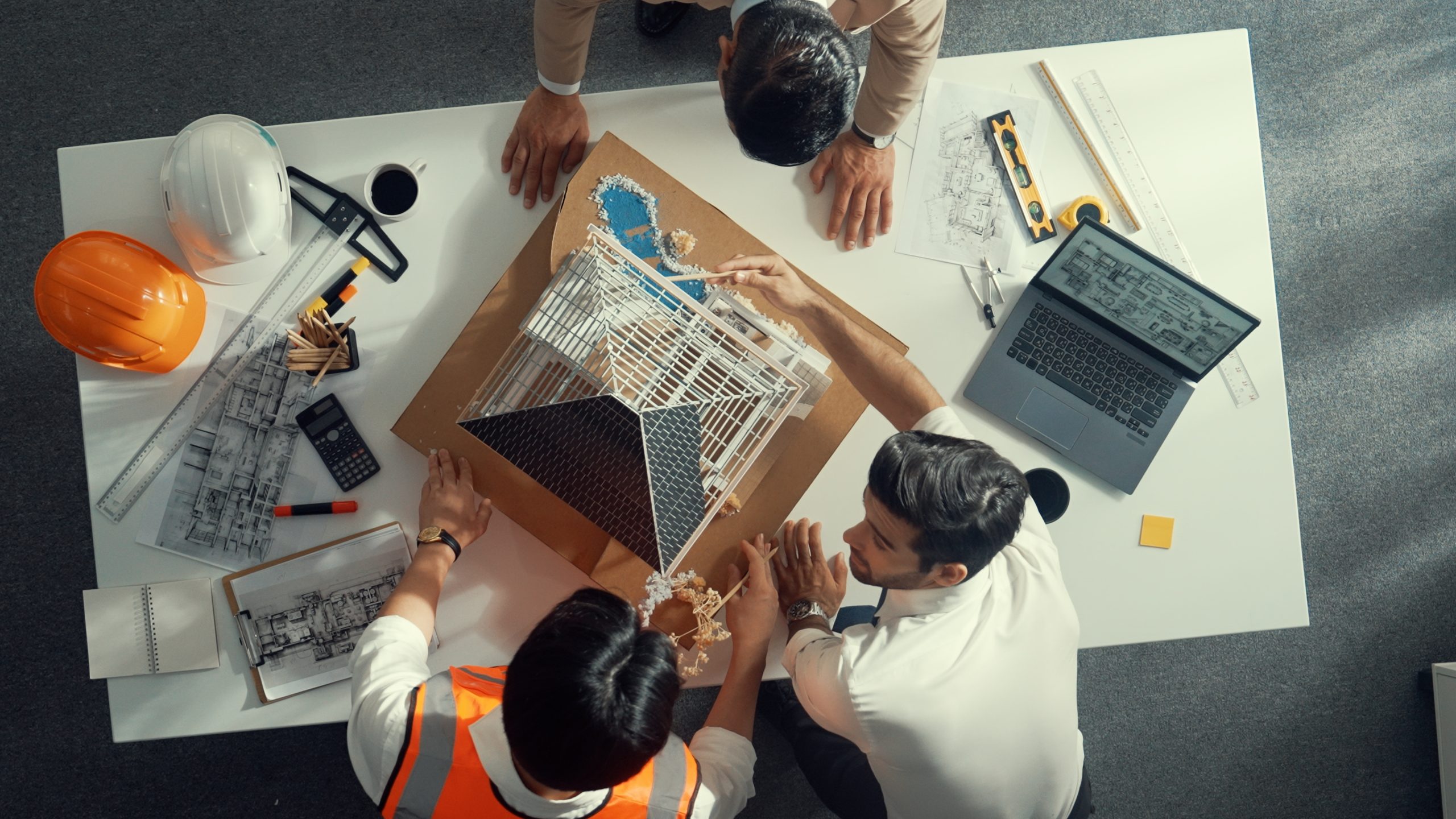 Services 2 Close up of civil engineer hand holding blueprint while working together to plan building construction by using house model and shaking hand or making a deal or contract with manager. Alimentation.